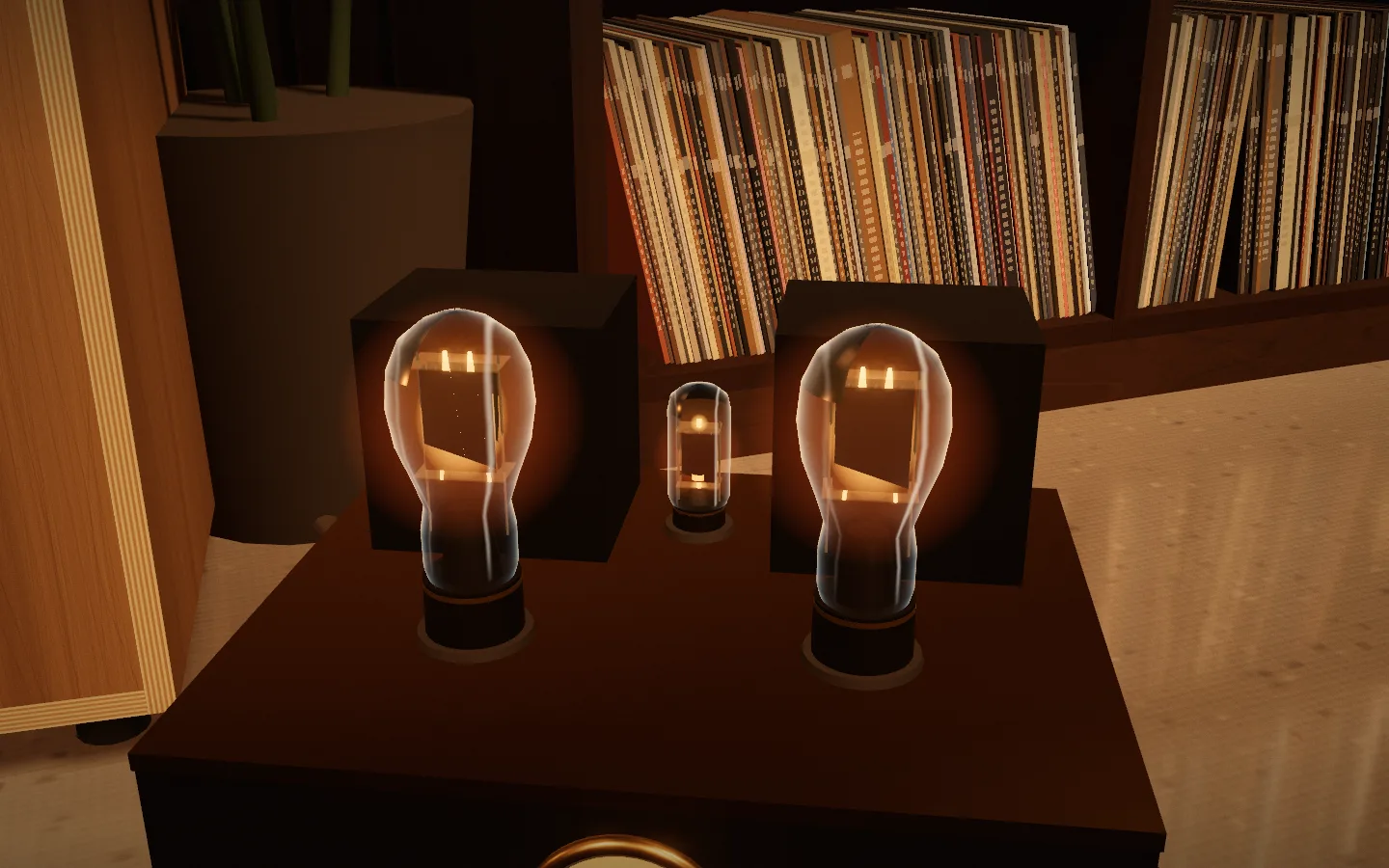 A tube monoblock up close: two clear glass output valves glowing amber in front of their transformers, a small driver valve between them, shelves of records behind