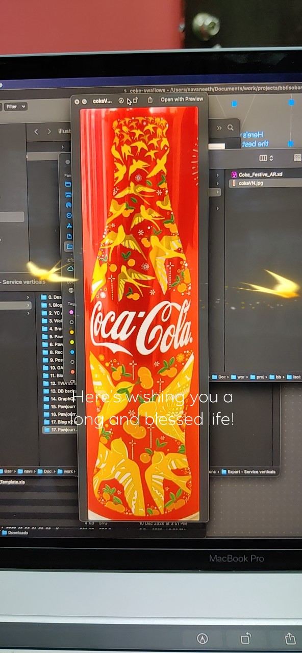 Portrait development capture with a red Coca-Cola can design, golden birds and a greeting overlay.